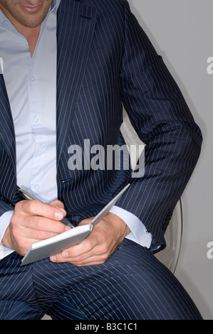 A businessman writing in a notepad Stock Photo