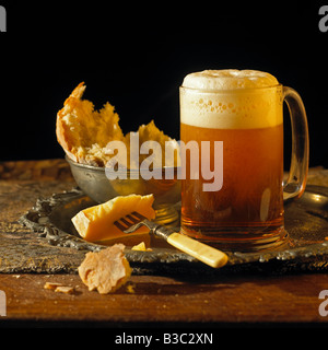A glass of ale on a plate with cheese Stock Photo