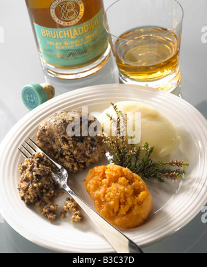 A haggis on a plate with a glass of whiskey Stock Photo