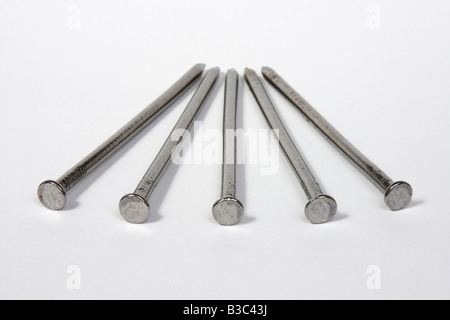 Five large nails on a white background Stock Photo