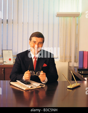 Front view of smiling business man sitting in office Stock Photo