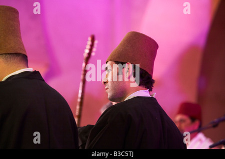 Morocco, Fes. Two dervishes wearing the traditional 'tombstone' hats, wait to perform during the Fes Festival of World Sacred Music. Stock Photo