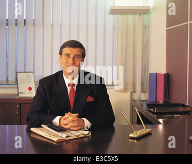 Front view of smiling business man sitting in office Stock Photo