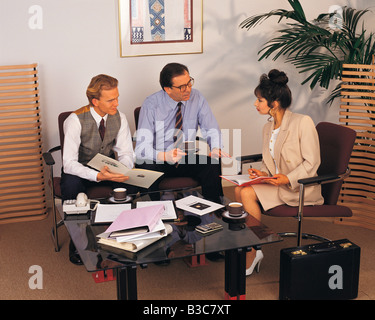 Three business professional executives meeting in office and having coffee Stock Photo