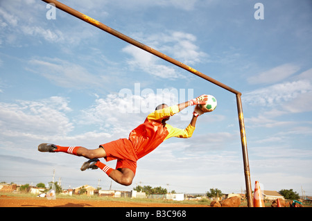 Soccer field, sports gear and man on field, tying shoe laces for
