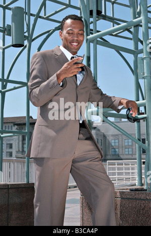 Happy Smiling African American Businessman Looking at Cell Phone Stock Photo