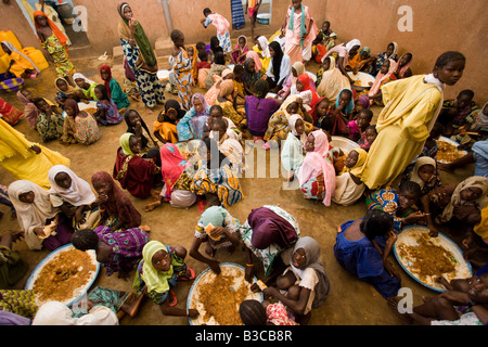 Girls gathered around large plates of food for lunch at the Mame Diarra Bousso koranic school in village of Porokhane Senegal Stock Photo