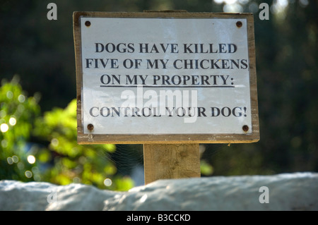 Sign reading Dogs have killed five of my Chickens on my property. Control Your Dog. Stock Photo