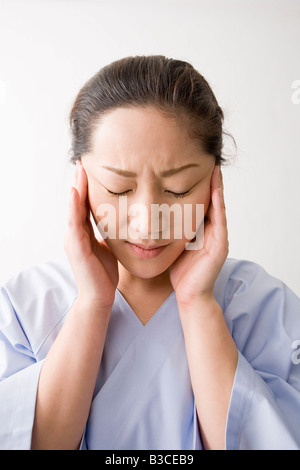 Mid adult woman suffering from headache Stock Photo