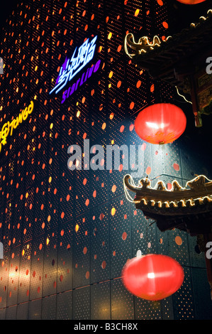 Chinese restaurant lanterns lit up by sunset on a busy shopping ...