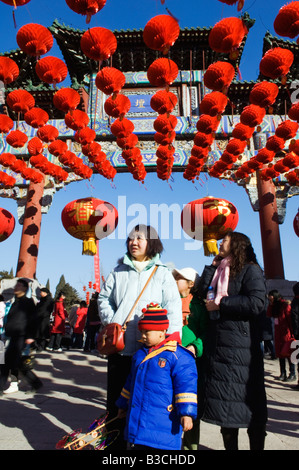 China, Beijing. Chinese New Year Spring Festival - A family under red lantern decorations at Ditan Park temple fair.