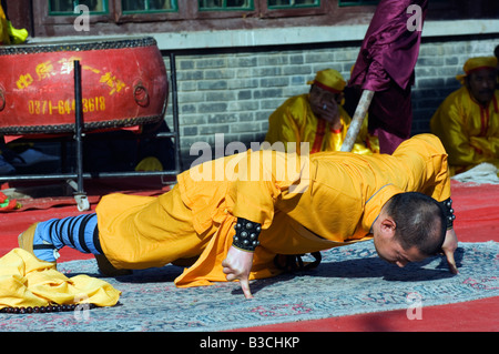 China, Beijing. Beiputuo temple and film studio - Chinese New Year Spring Festival - a monk performing one finger push ups. Stock Photo