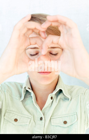 A young woman with her hands in front of her face. Stock Photo