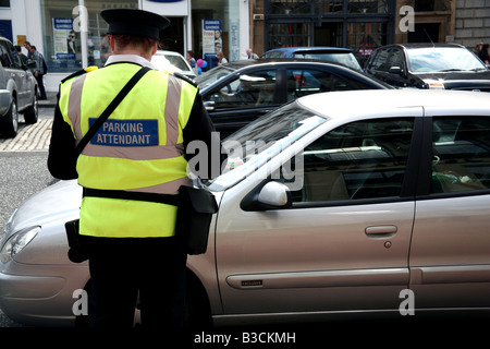 Parking warden issues ticket in Edinburgh street Stock Photo