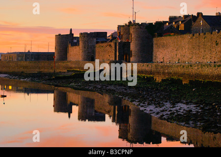 The outer walls of Caernarfon castle on the coast of North Wales in late evening sunshine Stock Photo