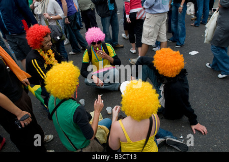 UNITED KINGDOM, ENGLAND, 25th August 2008. Revellers sit in the road during the Notting Hill Carnival in west London. Stock Photo