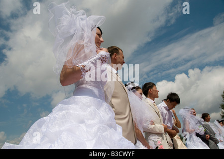 Kazakh brides and grooms during a simultaneously mass wedding ceremony in Arai park in Nur-Sultan or Nursultan capital of Kazakhstan Stock Photo