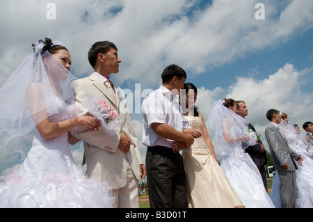 Kazakh brides and grooms during a simultaneously mass wedding ceremony in Arai park in Nur-Sultan or Nursultan capital of Kazakhstan Stock Photo