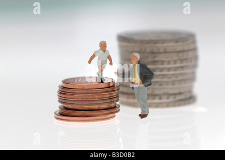 Plastic figurines and stack of coins Stock Photo