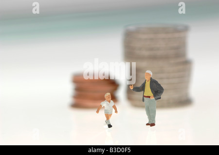 Plastic figurines and stack of coins Stock Photo