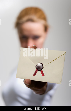 Woman holding wax-sealed envelope, close-up Stock Photo
