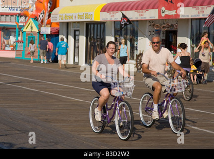 Couple riding bicycles on a boardwalk Stock Photo