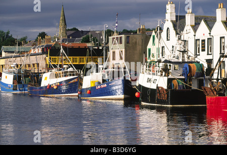 Fishing boats berth in scenic Eyemouth Harbour with town behind Berwickshire coast commuity Scottish Borders Scotland UK Stock Photo