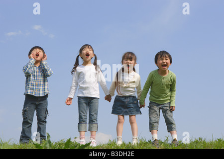 Children standing in a row and yelling together Stock Photo