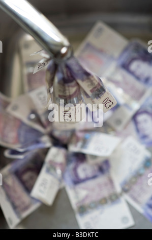 Pouring money down the drain concept Stock Photo