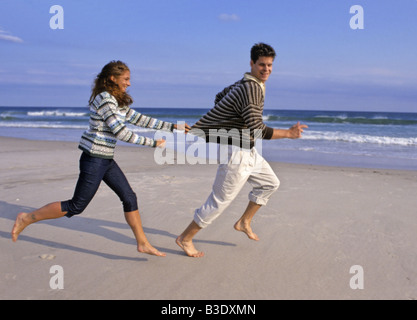 Couple running at the beach, having fun Stock Photo