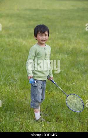 Boy playing badminton in park Stock Photo