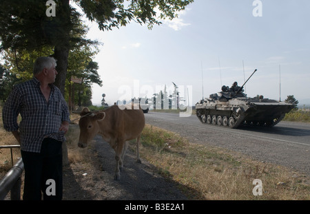 A Georgian villager looks at Russian armoured personnel carriers driving on the road between Gori - Tbilisi during the Russo-Georgian War August 2008 Stock Photo