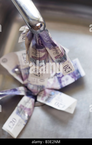 Pouring money down the drain concept Stock Photo