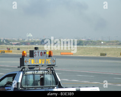 vehicle with stop follow me sign on airport tarmac Stock Photo