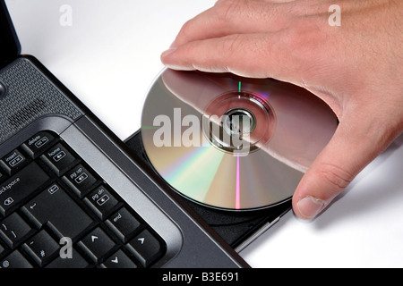 Inserting a CD into a CD rom drive on a laptop computer Stock Photo ...