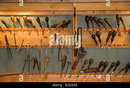 vintage leatherworking tools on a wall Stock Photo
