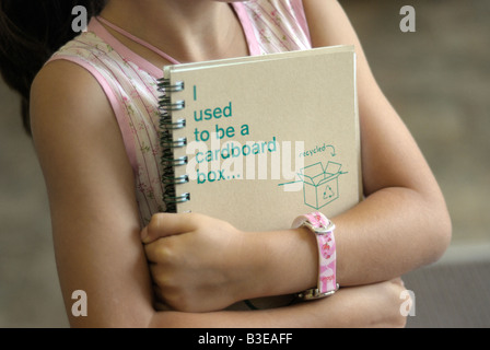 Child holds a school notebook made from recycled cardboard Stock Photo