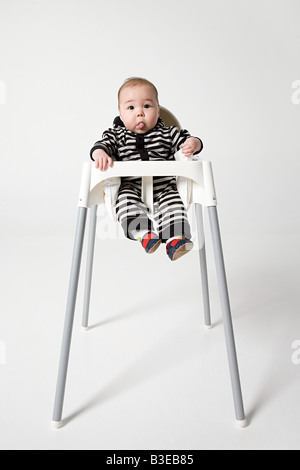 A baby in a high chair Stock Photo