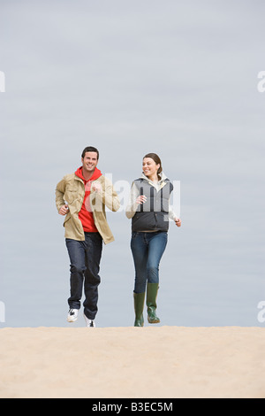 Young couple jogging on beach Stock Photo
