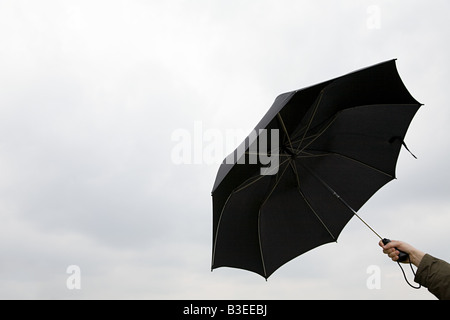 Person holding black umbrella against the rain Stock Photo