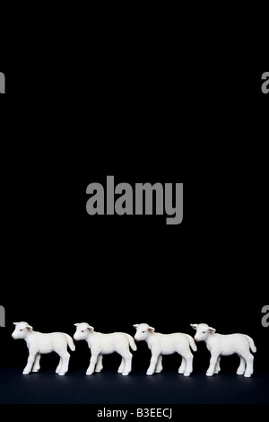 Four toy lambs in a row Stock Photo