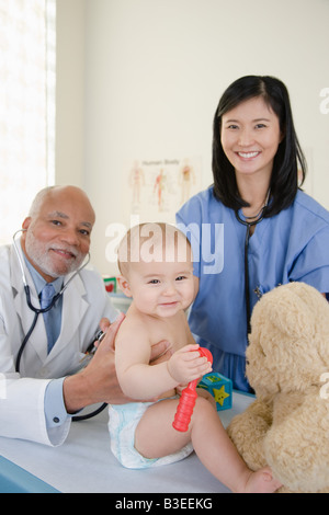 A doctor and nurse examining a baby Stock Photo