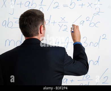 Man Looking at Calculations and Formula on a Whiteboard Stock Photo