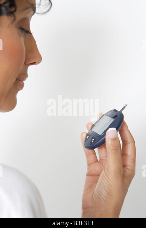 Woman checking diabetes test, close-up, studio shot Stock Photo