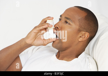 Man using inhaler in hospital bed Stock Photo