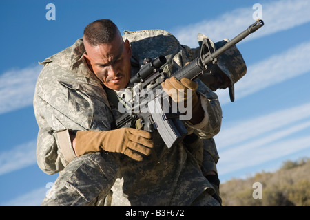US Army soldier carrying wounded soldier Stock Photo