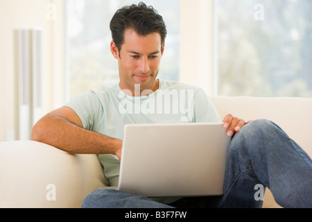 Man in living room using laptop Stock Photo