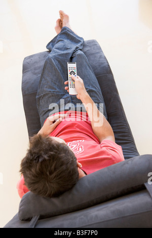 Man sitting in chair using remote control Stock Photo