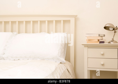 Empty bedroom with books on nightstand Stock Photo