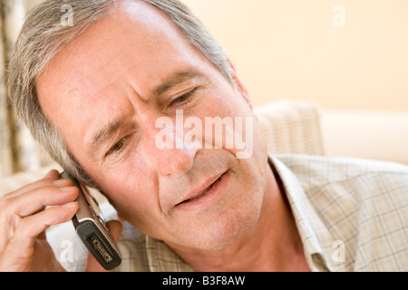 Man indoors using cellular phone Stock Photo